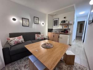 ein Wohnzimmer mit einer Couch und einem Holztisch in der Unterkunft Appart Standing - La Coque d'Or - Mont-St-Michel in Le Mont Saint Michel