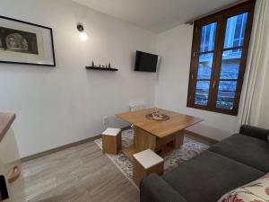 ein Wohnzimmer mit einem Tisch und einem Sofa in der Unterkunft Appart Standing - La Coque d'Or - Mont-St-Michel in Le Mont Saint Michel