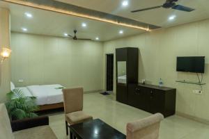 een hotelkamer met een bed en een tv bij Krazy Hotel in Haldwani