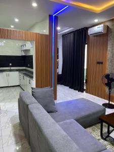 a living room with a couch and a kitchen at Boho apartment and spa in Lekki