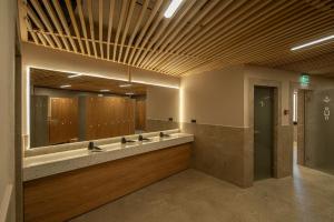 une salle de bain avec un lavabo et un grand miroir dans l'établissement Skigyimes Hotel, à Lunca de Sus 21 autres photos