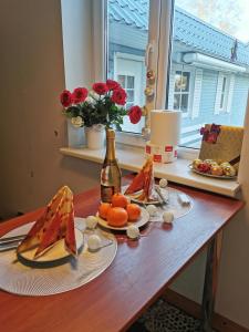 een tafel met fruitschalen en een fles wijn bij Jõe House in Valga