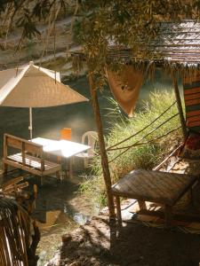 een patio met een tafel en stoelen en een parasol bij tawja surf house in Taghazout +18 foto's