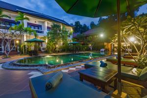 an image of a pool at a resort at night at De Arya Angkor Resort in Siem Reap