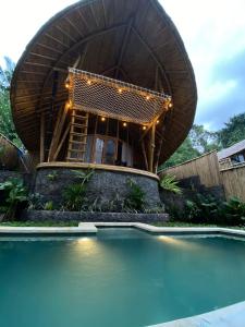 une maison ronde avec une piscine en face de celle-ci dans l'établissement Hidden Bamboo Village, à Selat