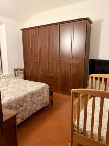 ein Schlafzimmer mit einem Bett und einem Holzschrank in der Unterkunft Molinella Appartamento Amelia & Carlo in Molinella
