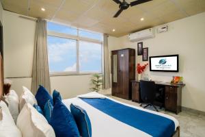 a bedroom with a bed and a desk and a window at Bnb Sakura , Golf Course Road in Gurgaon