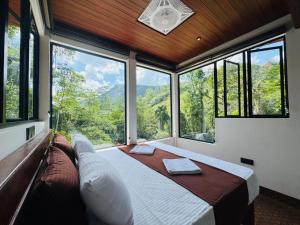 - une chambre avec un lit dans une pièce dotée de grandes fenêtres dans l'établissement Rainforest cabin, à Deniyaya 65 autres photos