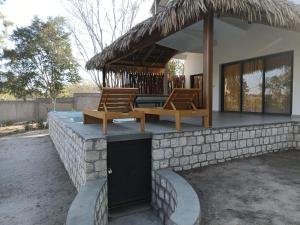 ein Gebäude mit 2 Stühlen und einer Terrasse in der Unterkunft Mangrov'Evasion in Mahajanga