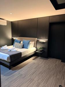 a bedroom with a large bed with blue pillows at Les Suites du Lac in Aix-les-Bains