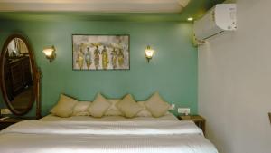 a bedroom with a bed and a green wall at Mariposa Beach Grove in Agonda +2 photos