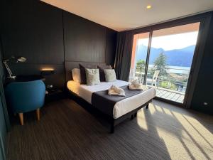 a hotel room with a bed and a large window at Les Suites du Lac in Aix-les-Bains
