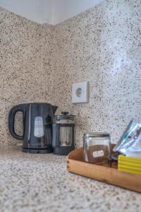 un piano di lavoro con macchinetta del caffè e bollitore per il tè di Villa iris Homestay a Uluwatu