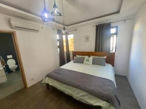 een slaapkamer met een groot bed in een kamer bij LS maison de vacance in Roche Bois