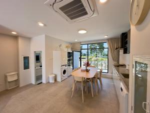 a kitchen and dining room with a table and chairs at RYANNA Samui in Choeng Mon Beach
