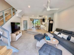 a living room with a couch and a table at RYANNA Samui in Choeng Mon Beach