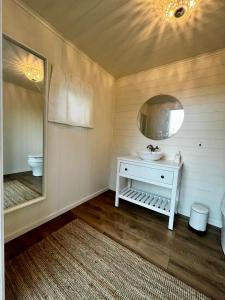 une salle de bains avec un lavabo et un miroir dans l'établissement Karamellgårdens stuga, à Herräng