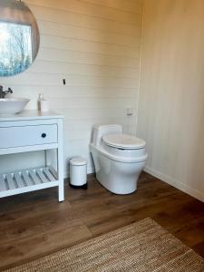 une salle de bain avec des toilettes blanches et un lavabo dans l'établissement Karamellgårdens stuga, à Herräng