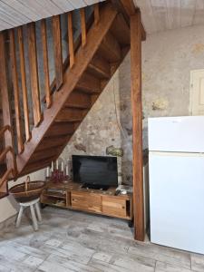 a living room with a tv and a refrigerator at La mare aux canards in Châteauvieux
