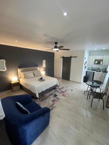 een slaapkamer met een bed en een blauwe bank bij Ukosi Brisa in Kloof