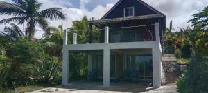 een huis met een grote glazen deur erbovenop bij Chez Pack et Ibu in Petite Île