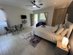 een slaapkamer met een bed, een tafel en stoelen bij Ukosi Brisa in Kloof