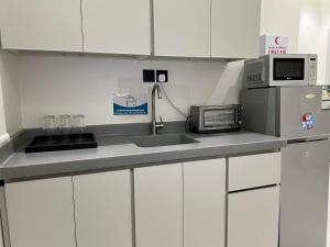 een keuken met een spoelbak en een magnetron bij SUKN Qiddiya- Al Muzahimiyah in Riyad