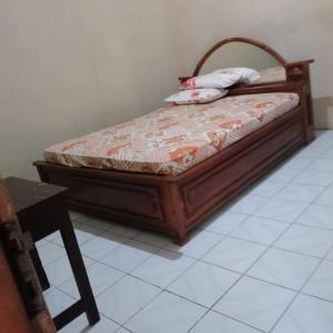 a bed with two pillows on it in a room at Baron Sari Homestay in Pulau Kukup