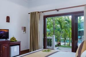 a living room with a sliding glass door to a patio at De Arya Angkor Resort in Siem Reap