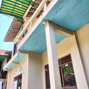 a house with a blue roof at Baron Sari Homestay in Pulau Kukup +1 photo