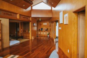 a large living room with wood floors and a ceiling at Nagoya in Nakijin