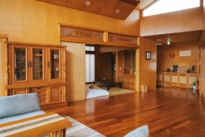 a large living room with wooden floors and a couch at Nagoya in Nakijin