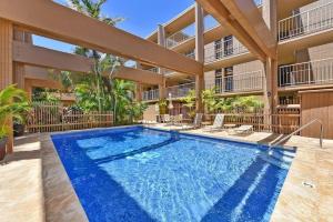 a swimming pool in front of a building at Kaleialoha 401 · KA 401 Spacious Studio w Mountain View Pool AC in Kahana
