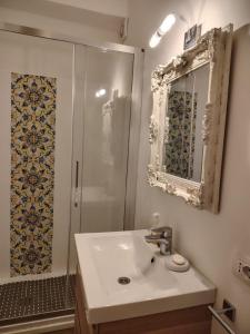 a bathroom with a sink and a shower with a mirror at Casa vista Faraglioni Capri in Capri +10 photos