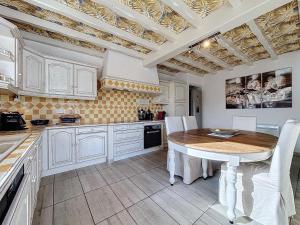 een keuken met een houten tafel en witte kasten bij Escale et Séjour in Lavaur +2 foto's