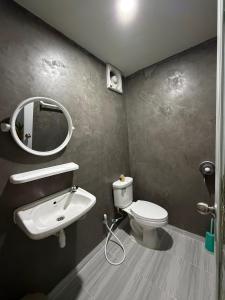 une salle de bains avec lavabo, toilettes et miroir dans l'établissement Greenview Room and Restaurant,  8 autres photos