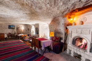 een eetkamer met een open haard in een grot bij Kapadokya Ihlara Konakları Otel Konak Odaları in Guzelyurt