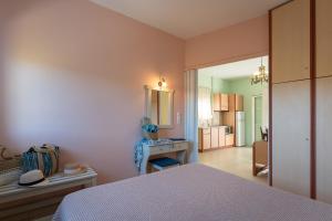 een slaapkamer met een bed, een tafel en een spiegel bij Dion Zois in Finikounta