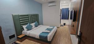 a bedroom with a large bed with a green headboard at Hotel Jalsa in Surat