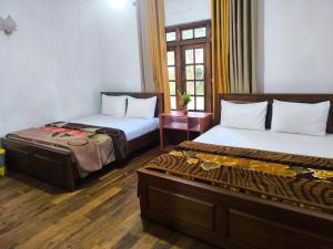 een hotelkamer met twee bedden en een raam bij Glenfall Guest in Nuwara Eliya