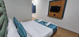 a small room with a bed and a tv at Hotel Jalsa in Surat