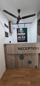 a ceiling fan in a room with a sign on the wall at Hotel Jalsa in Surat