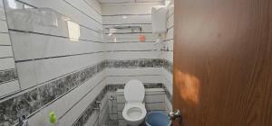a small bathroom with a toilet and a door at Hotel Jalsa in Surat +13 photos