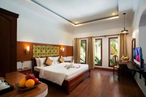 a bedroom with a large white bed and a television at De Arya Angkor Resort in Siem Reap +112 photos