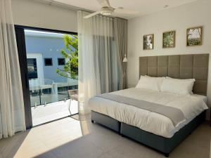 a bedroom with a large bed and a balcony at RYANNA Samui in Choeng Mon Beach +263 photos