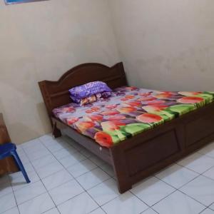 a bed with a colorful comforter and a stuffed animal on it at Baronsari GuestHouse in Pulau Kukup