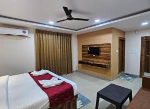 a hotel room with a bed and a flat screen tv at Hotel Park View in Akolia