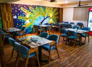 a dining room with tables and chairs and a mural at Hotel Park View in Akolia