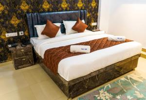 a bedroom with a large bed with pillows on it at Hotel Park View in Akolia