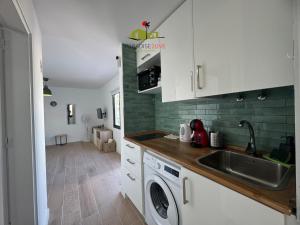 a kitchen with a sink and a washing machine at Casa Dudu in Corralejo